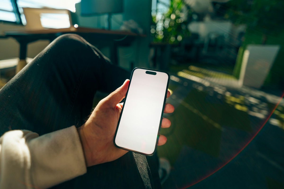スマートフォンの画面を確認する手元