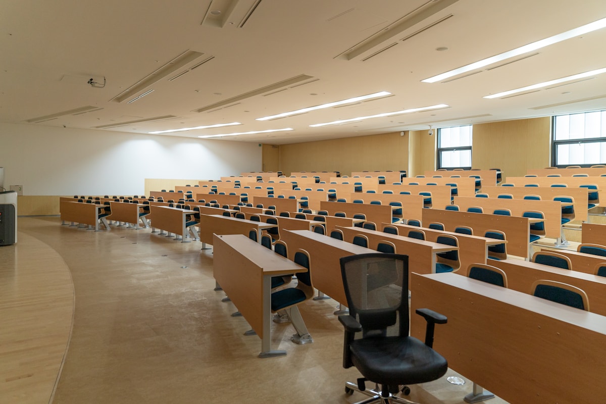 木製の机と椅子が並ぶ講義室